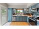 Well-lit kitchen with blue cabinets, stainless steel appliances, and a sliding glass door to the backyard at 4879 S Johnson St, Littleton, CO 80123