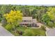 Stunning aerial view of a home surrounded by mature trees on a lush green property at 6128 S Coventry E Ln, Littleton, CO 80123