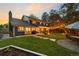 Large backyard with mature trees, manicured lawn, stone pavers, and patio area at 6128 S Coventry E Ln, Littleton, CO 80123