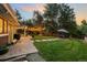 Expansive backyard with manicured lawn, mature trees, and inviting patio area at 6128 S Coventry E Ln, Littleton, CO 80123