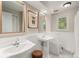 Bathroom featuring a pedestal sink, custom mirror, and a view to the backyard at 6128 S Coventry E Ln, Littleton, CO 80123