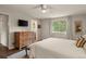 Serene bedroom with a view of the ensuite bathroom, TV, and hardwood floors at 6128 S Coventry E Ln, Littleton, CO 80123
