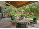Covered patio with outdoor seating, view of the backyard with mature landscaping and privacy fence at 6128 S Coventry E Ln, Littleton, CO 80123