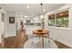 Open-concept kitchen with white cabinets and a dining area featuring a pendant light and hardwood floors at 6128 S Coventry E Ln, Littleton, CO 80123