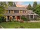 Charming two-story home featuring a landscaped yard and a welcoming front porch with beautiful sunset at 6128 S Coventry E Ln, Littleton, CO 80123
