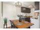 Cozy dining area with modern light fixture, wooden table, and access to the kitchen at 799 Dahlia St # 503, Denver, CO 80220