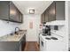 Functional kitchen with granite countertops, dark cabinets, and white appliances at 799 Dahlia St # 503, Denver, CO 80220
