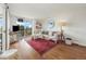 Bright living room with sliding glass doors to a balcony and a large red rug on hardwood floors at 799 Dahlia St # 503, Denver, CO 80220