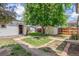 View of the home's backyard, including grass, trees, shed, and detached garage at 2845 Eaton St, Wheat Ridge, CO 80214
