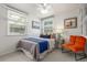 Cozy bedroom with large windows, bright natural light and a comfortable orange armchair at 2845 Eaton St, Wheat Ridge, CO 80214