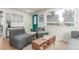 Bright living room featuring a modern sofa, stylish seating, and natural light from large windows with blinds at 2845 Eaton St, Wheat Ridge, CO 80214