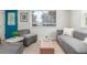 Bright living room featuring a modern sofa, stylish seating, and natural light from large windows with blinds at 2845 Eaton St, Wheat Ridge, CO 80214