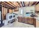 Unfinished basement area featuring laundry machines, cabinets, and ample storage space at 12425 Bellaire Dr, Thornton, CO 80241