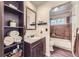 Bathroom featuring a vanity, mirror, shelves, and bath tub/shower combo with brown tile at 12425 Bellaire Dr, Thornton, CO 80241