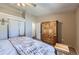 Bedroom features a faux fur throw blanket, dresser, and an ensuite bathroom at 12425 Bellaire Dr, Thornton, CO 80241