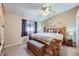 Spacious bedroom featuring carpet floors, a ceiling fan, and a large bed and bench at 12425 Bellaire Dr, Thornton, CO 80241