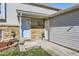 Charming home entrance features brick accents and a welcoming vibe with potted plants and a decorated welcome mat at 12425 Bellaire Dr, Thornton, CO 80241