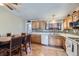 Open kitchen and dining area featuring wooden cabinets, granite countertops, and modern appliances at 12425 Bellaire Dr, Thornton, CO 80241