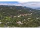 Aerial view of luxury homes nestled in a forest with winding roads and mountain views at 1952 Columbine Ct, Golden, CO 80401