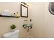 Powder room featuring glass bowl sink, decorative mirror, and a sleek modern design at 1952 Columbine Ct, Golden, CO 80401