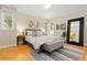 Bright bedroom with hardwood floors, large mirror, bench seat, and a neutral color palette at 1952 Columbine Ct, Golden, CO 80401
