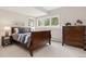 Cozy bedroom with wood sleigh bed, dresser, soft carpet, and large window letting in natural light at 1952 Columbine Ct, Golden, CO 80401