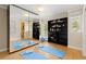 Home exercise room with mirrored wall, hardwood floors, and built-in shelving at 1952 Columbine Ct, Golden, CO 80401