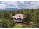 Stunning exterior elevation of mountain home with a deck and lovely landscaping surrounded by mature trees at 1952 Columbine Ct, Golden, CO 80401