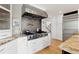 Modern kitchen featuring a stainless steel range hood, granite counters, and white cabinets at 1952 Columbine Ct, Golden, CO 80401