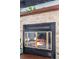 Close-up of a fireplace with a stone surround and glass doors at 10280 W Jewell Ave # B, Lakewood, CO 80232