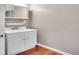 Bathroom with a white sink cabinet, vanity mirror, and wood-look flooring at 8047 Lee Ct, Arvada, CO 80005