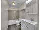 Clean bathroom featuring gray tile floors, a tiled shower/tub, and a white vanity at 8047 Lee Ct, Arvada, CO 80005