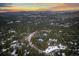 Aerial view of a home nestled in a forest-like neighborhood with snow-dusted mountains in the background at 2828 Keystone Dr, Evergreen, CO 80439