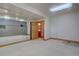 Spacious basement room featuring mirrored wall and access to an ensuite bathroom, perfect for a home gym at 2828 Keystone Dr, Evergreen, CO 80439