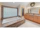 Luxurious bathroom featuring granite countertops, a soaking tub, and a large glass block window at 2828 Keystone Dr, Evergreen, CO 80439