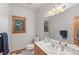 Bathroom with a tiled floor, wood cabinets, a granite-style countertop, and a window providing natural light at 2828 Keystone Dr, Evergreen, CO 80439