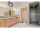 Bathroom featuring a double vanity with granite countertops, a shower, and a separate toilet at 2828 Keystone Dr, Evergreen, CO 80439