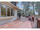 Large wooden deck with built-in stone grill and seating, perfect for outdoor entertaining surrounded by mature trees at 2828 Keystone Dr, Evergreen, CO 80439