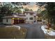Stunning home featuring a tile roof, mature trees, and a circular driveway leading to an attached two-car garage at 2828 Keystone Dr, Evergreen, CO 80439