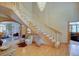Bright foyer with a curved staircase, chandelier, and hardwood floors at 2828 Keystone Dr, Evergreen, CO 80439