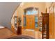 Expansive foyer with gleaming hardwood floors, staircase, large front door, and decorative accents at 2828 Keystone Dr, Evergreen, CO 80439