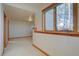 Hallway with natural light through a window highlighting neutral colors of the walls and flooring at 2828 Keystone Dr, Evergreen, CO 80439