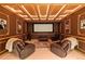 Finished basement theater with leather recliners and a large screen for entertainment at 2828 Keystone Dr, Evergreen, CO 80439