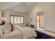 Light-filled main bedroom features a large window, neutral decor, high ceilings, and access to the ensuite at 2828 Keystone Dr, Evergreen, CO 80439
