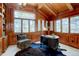 Stylish home office with wood paneling, a large window, and custom built-ins at 2828 Keystone Dr, Evergreen, CO 80439