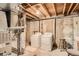 Unfinished basement laundry area, complete with utility sink and included washer and dryer at 400 S Balsam St, Lakewood, CO 80226