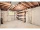 Unfinished basement with window and shelving offers potential for storage and customization at 400 S Balsam St, Lakewood, CO 80226