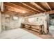 Unfinished basement with exposed wood beams and concrete walls offers potential for customization at 400 S Balsam St, Lakewood, CO 80226