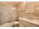 Bright bathroom featuring a shower and tub combo with a frosted shower door, a white vanity and sink at 400 S Balsam St, Lakewood, CO 80226