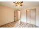 A bedroom with wood floors, a fan, closet, and a door to another room at 400 S Balsam St, Lakewood, CO 80226